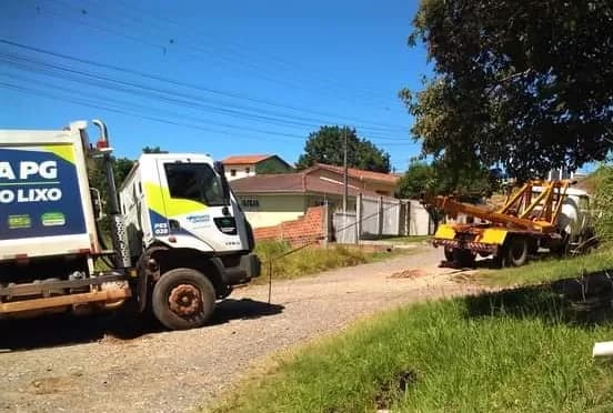 Caminhão de lixo cai em valeta de rua precária e é retirado por guincho em bairro de PG