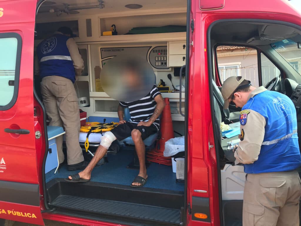 Jovem fere joelho com facão durante poda de árvore em PG