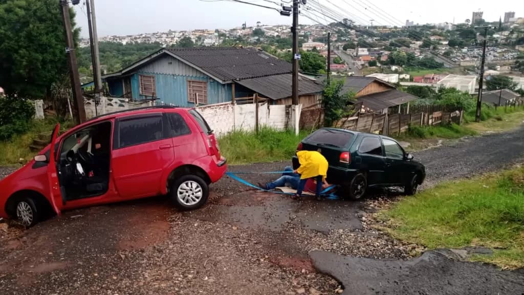Carro fica atolado depois de cair em cratera de rua em PG