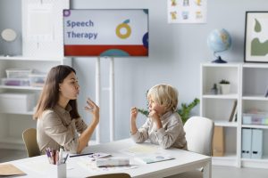 woman-doing-speech-therapy-with-little-blonde-boy 1