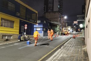 Imagem mostra trabalhadores realizando sinalização durante a noite